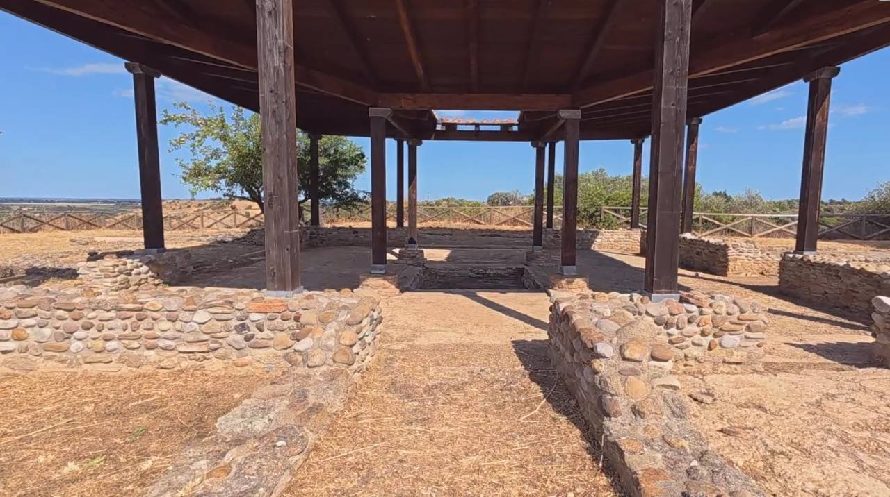 una struttura con pilastri in pietra e un muro in pietra