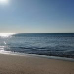 una spiaggia con uno specchio d'acqua e un cielo blu