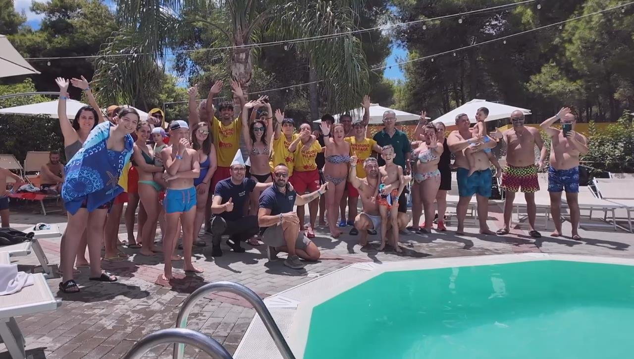 un gruppo di persone in posa per una foto a bordo piscina