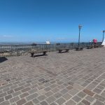 coppia di persone in piazza con vista mare
