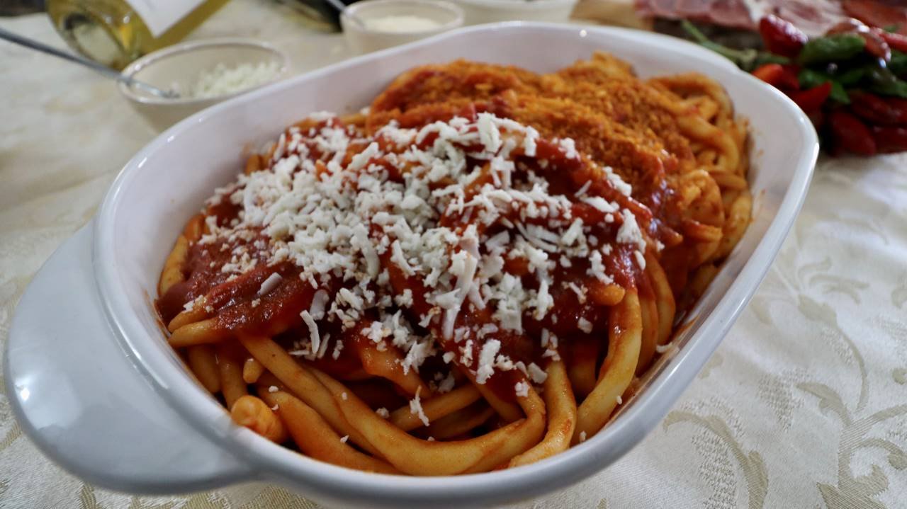un piatto di pasta con sugo e formaggio grattugiato